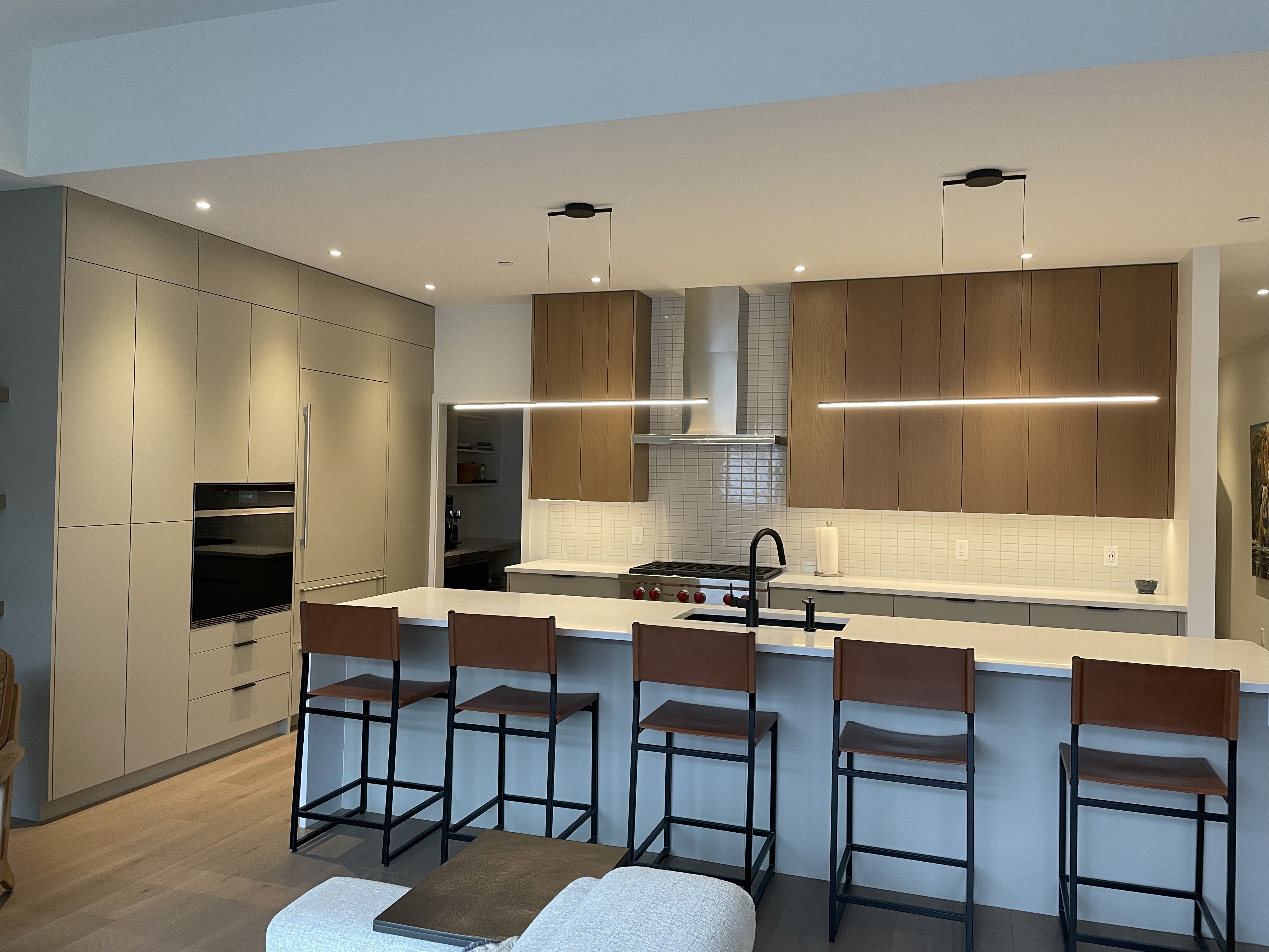 Finished custom kitchen in the West Kootenay with white oak upper cabinets and a quartz island