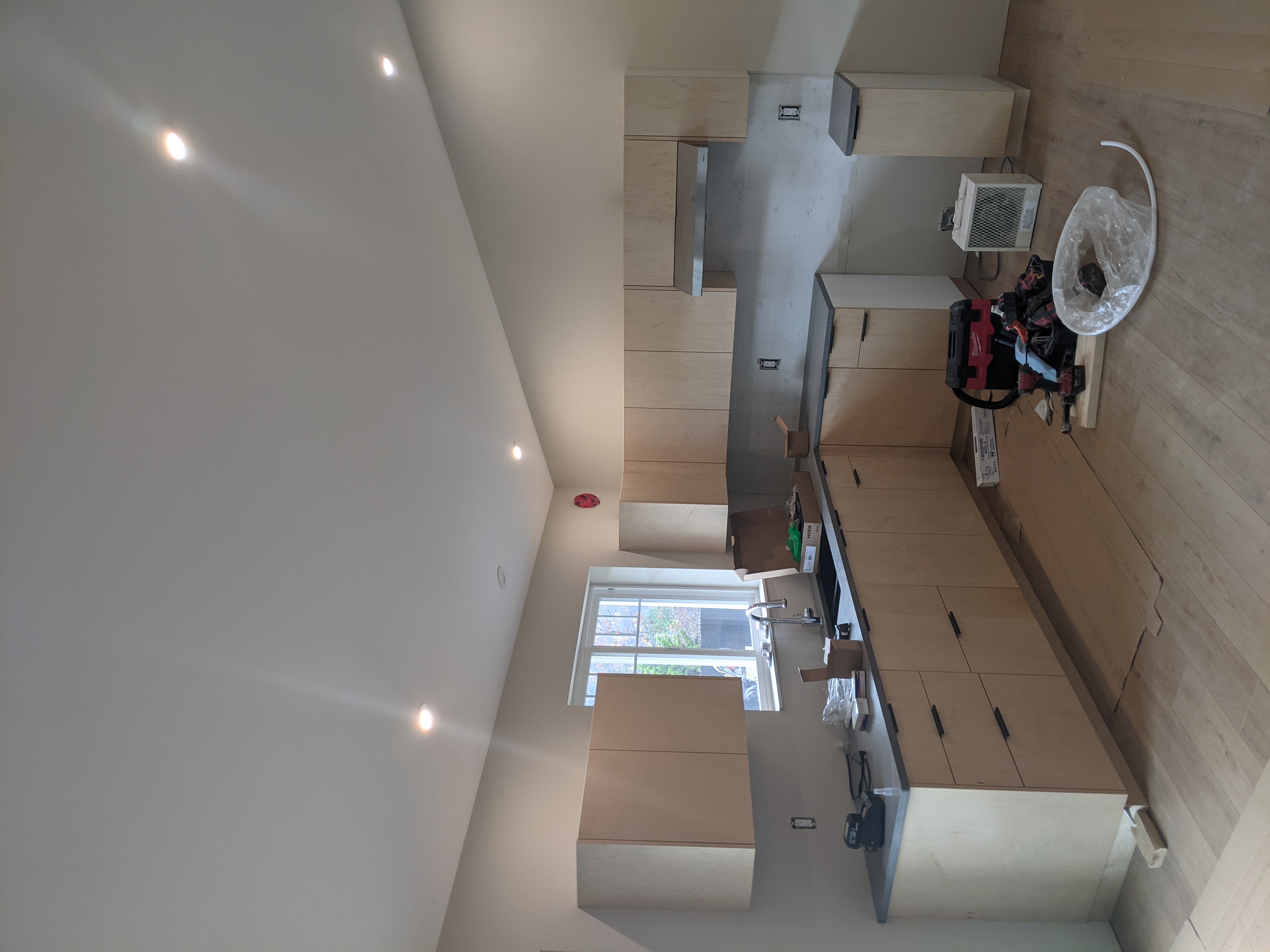 Light maple cabinets being installed, with tools still on the countertop